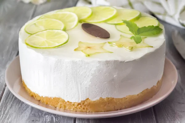 Gâteau rond beurre blanc sucré avec du citron vert tranché sur le dessus — Photo
