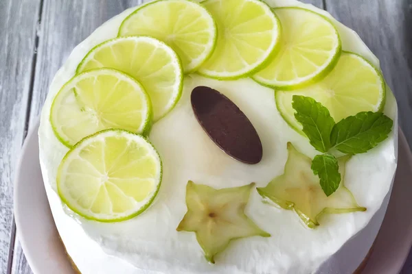 Gâteau rond beurre blanc sucré avec du citron vert tranché sur le dessus — Photo