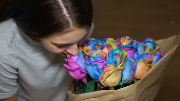 Jovem mulher está cheirando buquê de rosas arco-íris — Vídeo de Stock