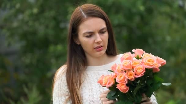 Une femme tenant un bouquet de fleurs à l'extérieur. 4k — Video