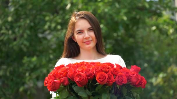 Beeldmateriaal vrouw met een boeket rozen buitenshuis. 4k — Stockvideo