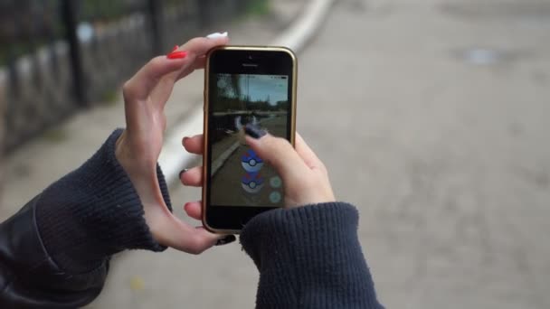 Samara, Rússia - 30 de setembro de 2016: mulher jogando pokemon ir em seu iphone. pokemon ir jogo multiplayer com elementos da realidade aumentada. Pegando o pokemon Pinsir — Vídeo de Stock