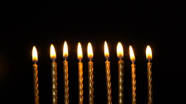 Goldene brennende Kerzen auf schwarzem Hintergrund. 4k — Stockvideo