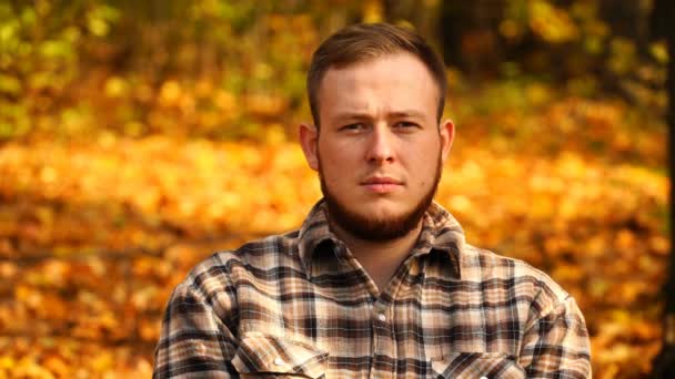 Footage portrait of a man looking at the camera outdoors in autumn. 4K — Stock Video