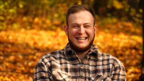 Beeldmateriaal portret van een man die lacht de camera buiten in herfst. 4k — Stockvideo