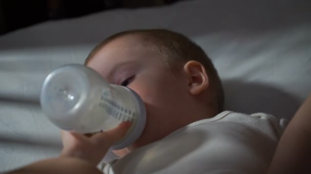 Beeldmateriaal baby baby eten uit een fles. 4k — Stockvideo