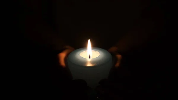 Hořící svíčka v rukou žen. — Stock fotografie