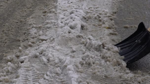 Ein Mann räumt Schnee von der Bauhofschaufel. Zeitlupe 120 fps Video. — Stockvideo