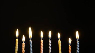 siyah arka plan üzerinde renkli yanan mumlar ayarla