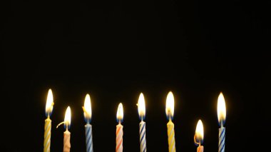 siyah arka plan üzerinde renkli yanan mumlar ayarla