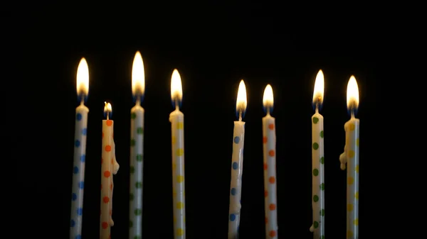Colorful burning candles set on black background — Stock Photo, Image