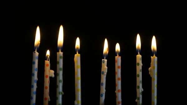 Красочные горящие свечи на черном фоне — стоковое фото