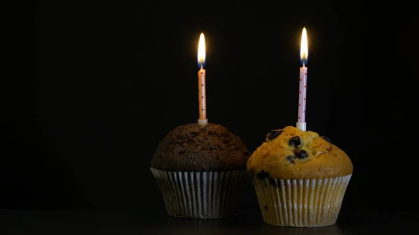 Muffin mit Kerze in Nahaufnahme auf schwarzem Hintergrund — Stockfoto