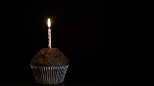 Μήκος σε πόδηα muffin με ένα κερί που κλείνουν σε μαύρο φόντο. βίντεο 4k — Αρχείο Βίντεο