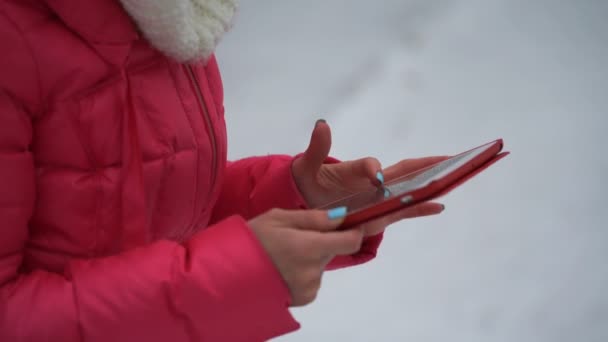 Жінка використовує планшет на відкритому повітрі взимку. 4k — стокове відео