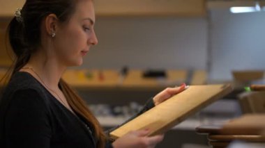 kadın bir kesme tahtası dükkanda seçer..