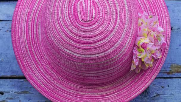 Розовая шляпа висит на деревянном фоне стены . — стоковое видео