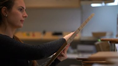 kadın bir kesme tahtası dükkanda seçer..