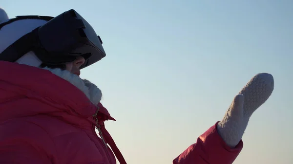 Meisje kijkt in de virtual reality bril buiten in de winter. — Stockfoto