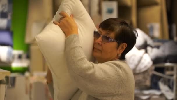 Γυναίκα επιλέγει ένα μαξιλάρι στο κατάστημα. — Αρχείο Βίντεο