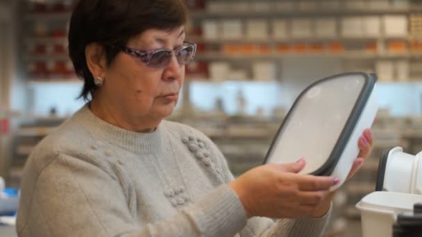 Mulher em uma loja comprando um recipiente de plástico para alimentos . — Vídeo de Stock