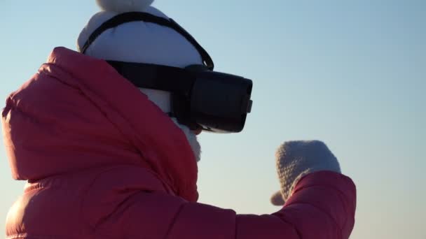 Mädchen schaut im Winter in der Virtual-Reality-Brille nach draußen. — Stockvideo