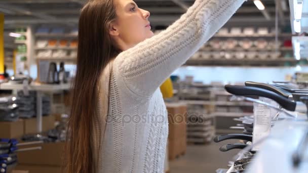 Vrouw een koekenpan in de winkel kopen. — Stockvideo