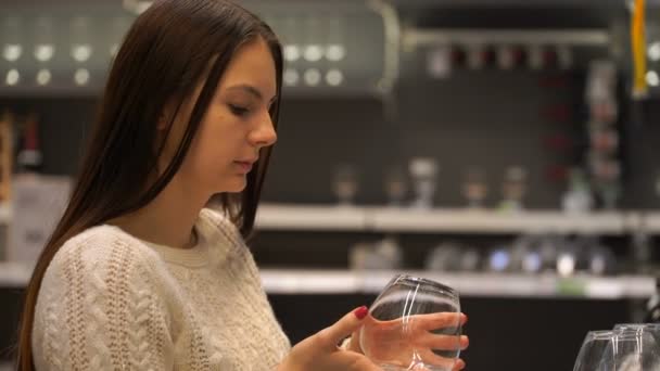 Frau kauft im Laden ein Glas Wein. — Stockvideo