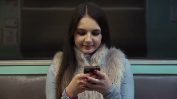 Vrouw rijdt metro en print sms op uw smartphone. — Stockvideo