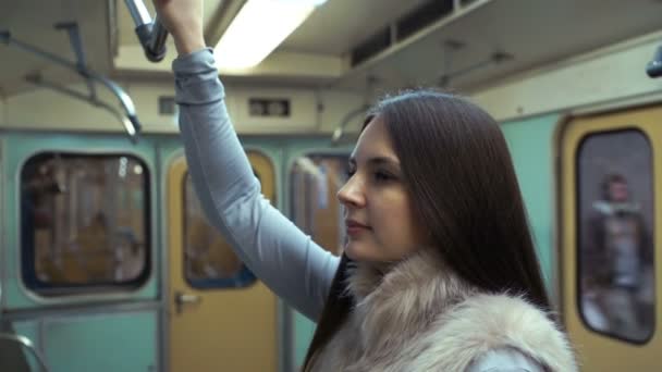 Mladá dívka jede na metro a držel madla. — Stock video