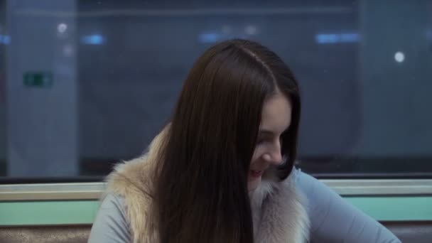 Brunette meisje rijdt op de metro en antwoord de oproep. — Stockvideo