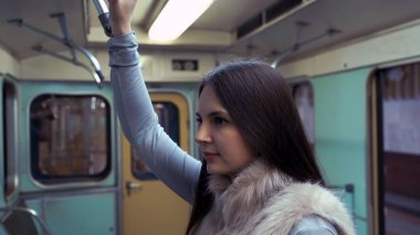 genç kız metroda sürmek ve Küpeşte düzenlenen.