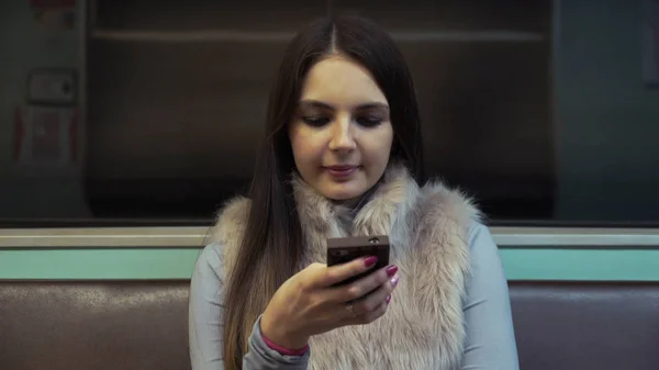 Женщина едет в метро и распечатывает смс на вашем смартфоне . — стоковое фото