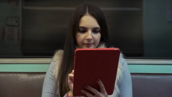 Brunette fille promenades dans le métro et en utilisant touchpad . — Photo
