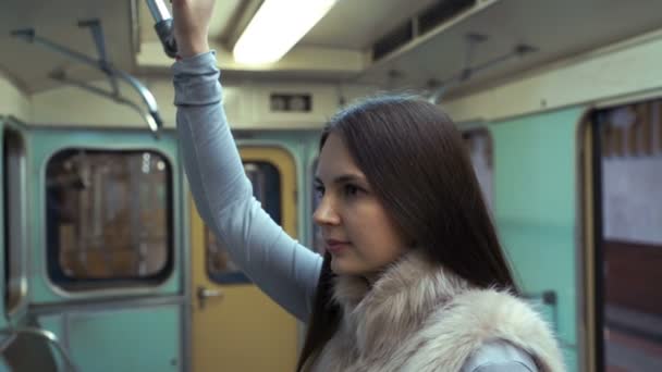 若い女の子が地下鉄に乗ってし、手すりを開催. — ストック動画