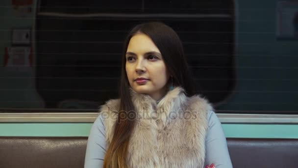 Morena chica paseos en el metro y mira a la distancia . — Vídeos de Stock