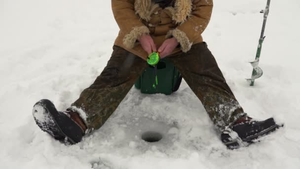 Fiskare fångar en fisk på isfiske. — Stockvideo