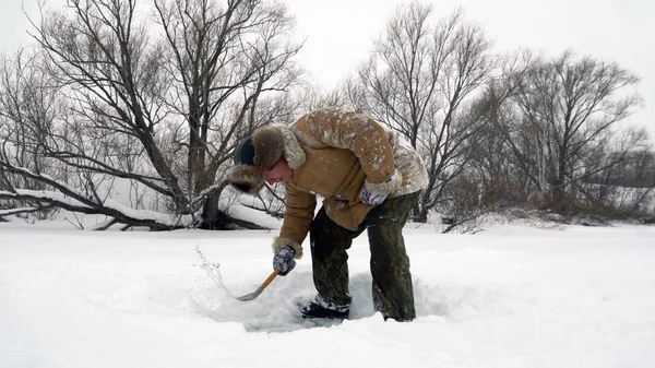 Pescador captura un pez en la pesca con hielo . — Foto de Stock