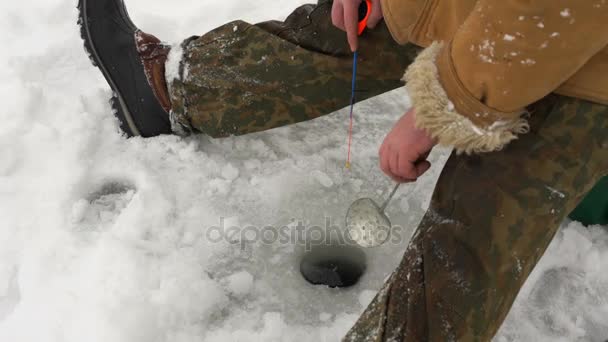 Fiskare fångar en fisk på isfiske. — Stockvideo