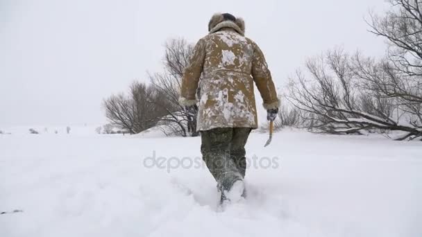 Rybář, otvor na jezero pokryté sněhem při hledání dobré rybářské místo. — Stock video