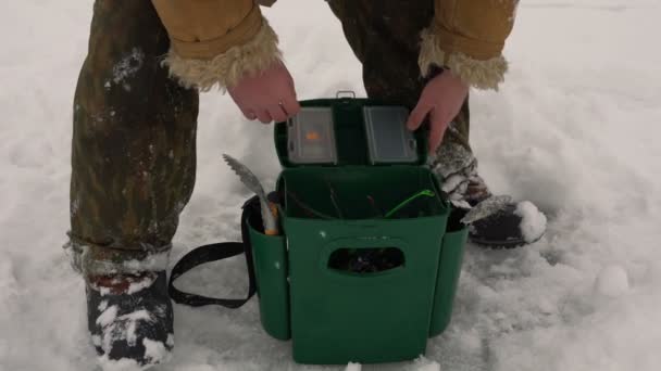 Рибалка витягує рибальський стрижень з коробки — стокове відео