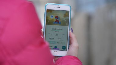 Samara, Rusya Federasyonu - 7 Mart 2017: kadın oyun pokemon git onun iphone 6s artı. Pokemon artar gerçeklik unsurları ile multiplayer oyun gitmek.
