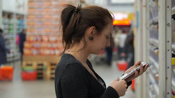 Mujer compra chocolate en un supermercado . — Foto de Stock