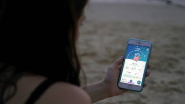 Phuket, Tayland - 28 Şubat 2017: kadın oyun pokemon git onun iphone 6s artı. Pokemon artar gerçeklik unsurları ile multiplayer oyun gidin. Corsola yakalandı.