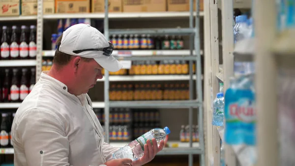Человек покупает минеральную воду в супермаркете или магазине . — стоковое фото