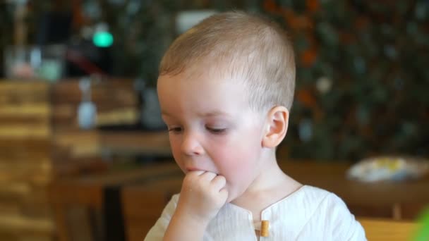 Il bambino mangia in un caffè . — Video Stock