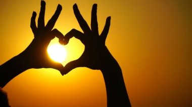 Kadın kalp yapar ve eller gün batımını yönlendirir