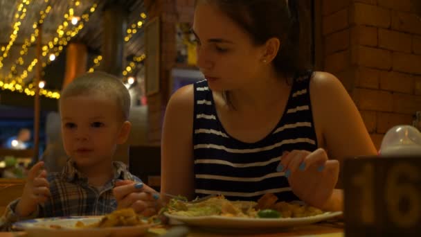 Beeldmateriaal moeder en zoon eten in een café. — Stockvideo