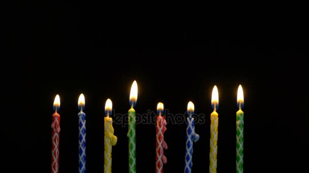 Footage colorful burning candles set on black background. 4k — Stock Video