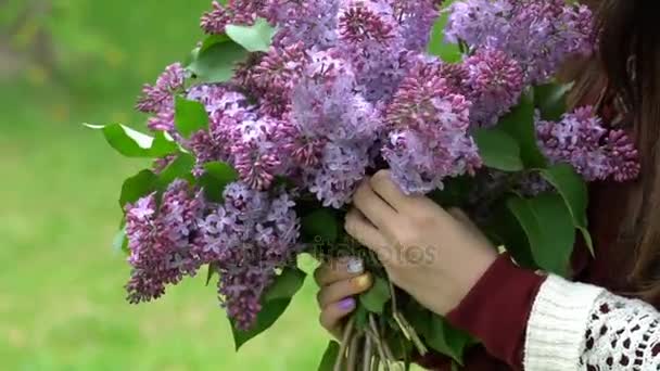 Mujer sosteniendo un ramo de lilas en flor . — Vídeo de stock